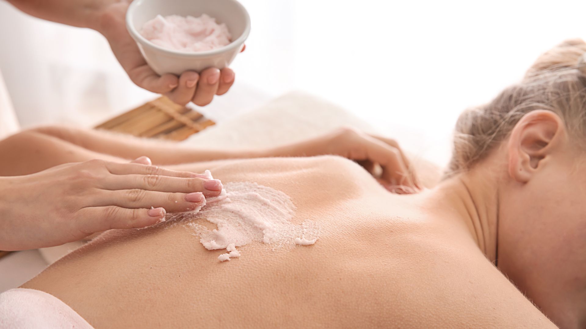 woman receiving body scrub