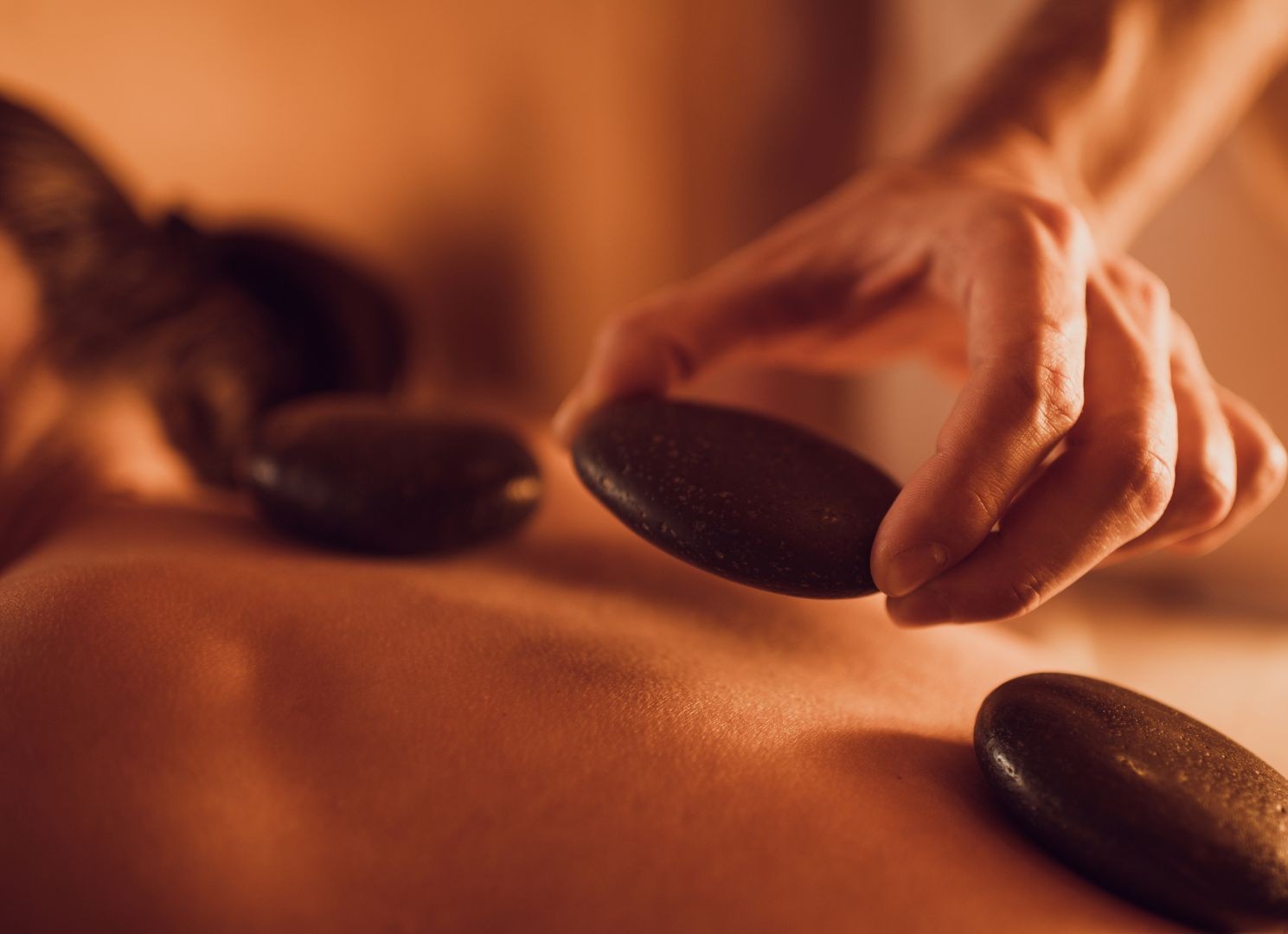 person receiving hot stone CBD massage